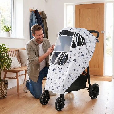 Housse de pluie universelle poussette Espace – papa installant la housse dans l'entrée de la maison