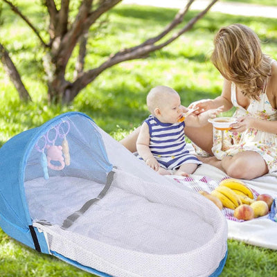 Lit de voyage pour bébé bleu BabyCocoon™ installer  au sol  au parc pour un pique-nique