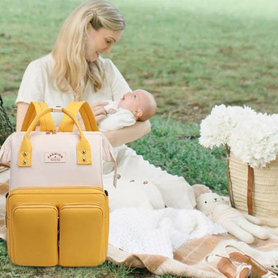 Sac a langer jaune maman assise souriant  à bébé en pique-nique
