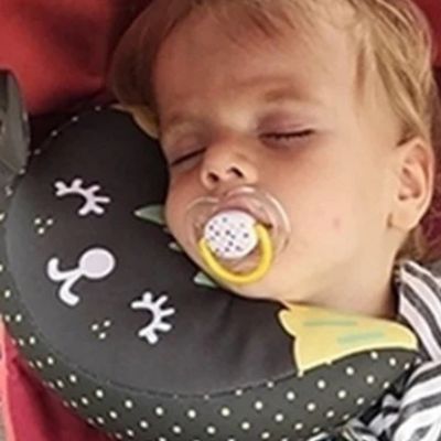 Support de tête et cou bébé | DodoBanana™ noir – enfant qui dort dans poussette avec sa suce