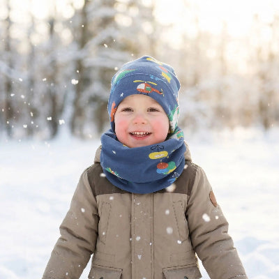 Tour de cou bebe bleu sur enfant souriant à peau sensible en sortie hivernale