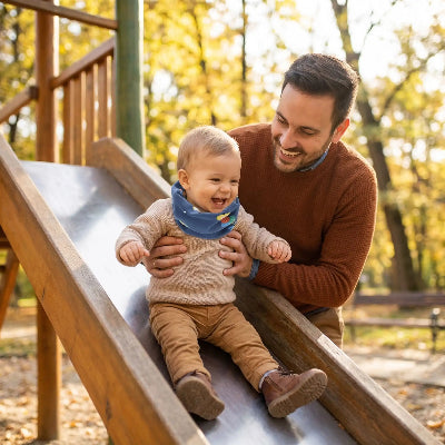 Tour de cou bleu sur bébé glissant avec papa au parc