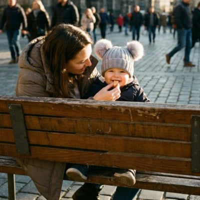 Bonnet bebe gris assis avec maman sur un banc