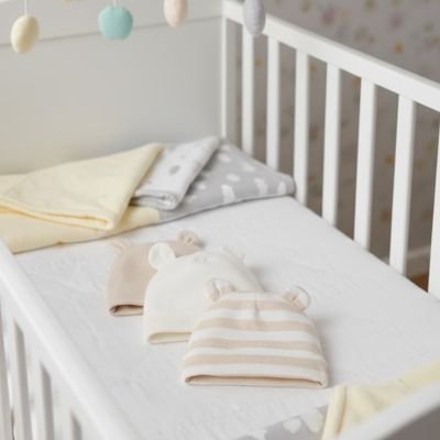 Bonnet bébé neutre étendue dans le berceau