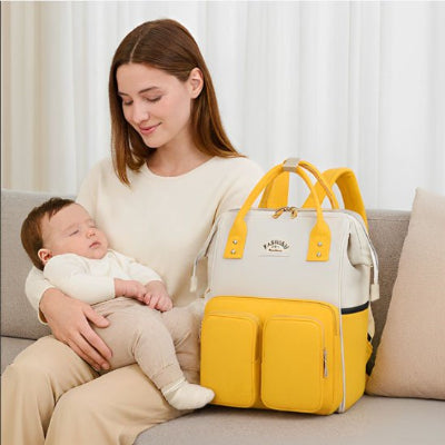 Sac a langer jaune sur un sofa avec maman et bébé dans les bras
