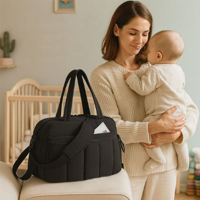 Sac a langer noir avec bébé dans les bras
