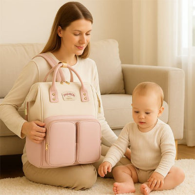 Sac a langer rose avec bébé et maman assis au sol dans salon