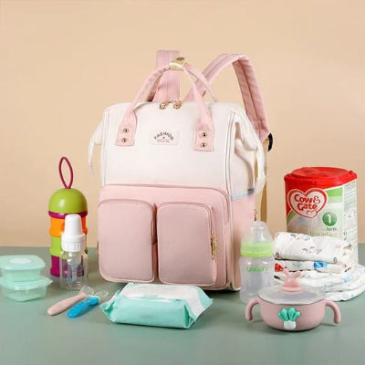 Sac a langer rose sur une table avec articles à introduire