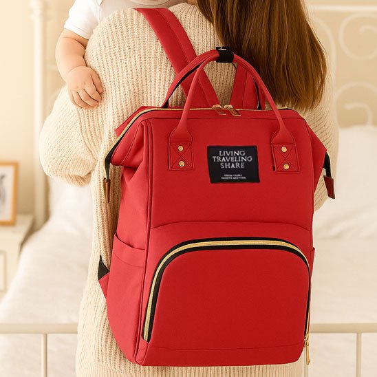 Sac a langer rouge maman debout avec bébé  dans les bras